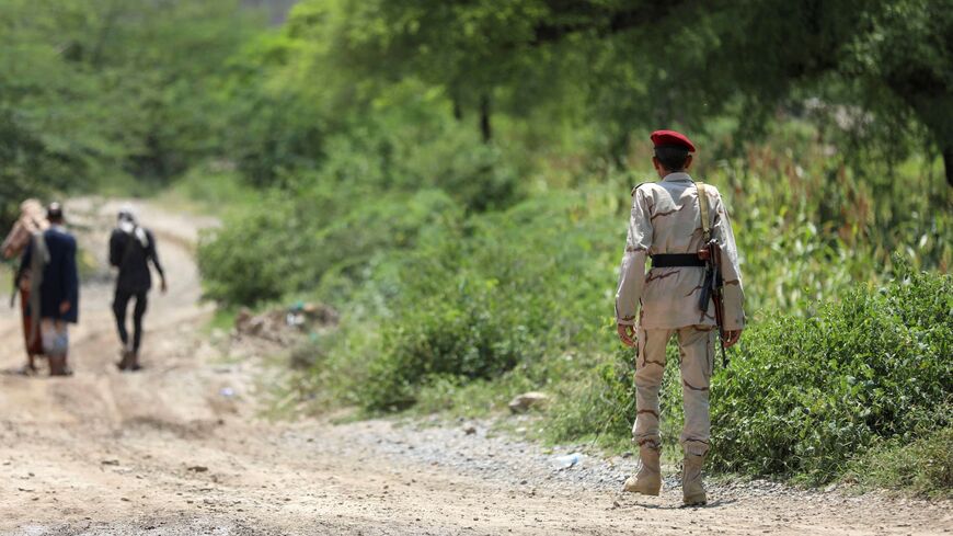 Saudi-backed Yemeni government forces walk along a dirt road