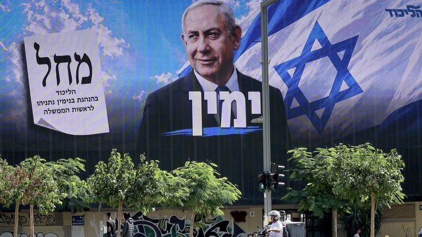 A man on a scooter rides past a billboard featuring Israel's Prime Minister Benjamin Netanyahu of the Likud party, in Tel Aviv, on Oct. 20, 2026. 