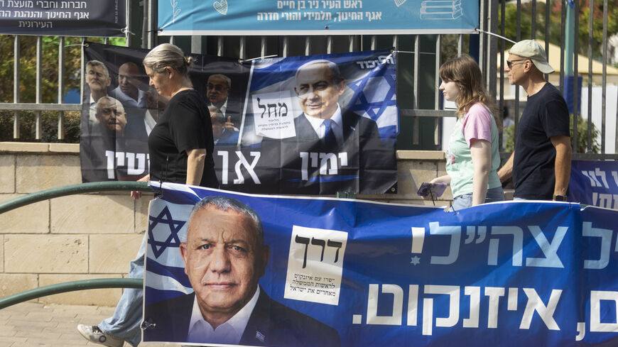 Israelis pass by campaign posters featuring Israeli Prime Minister, Benjamin Netanyahu, and Yashar Party leader, Gadi Eisenkot, near a polling station during Israel's general elections on October 27, 2026 in Hadera, Israel.
