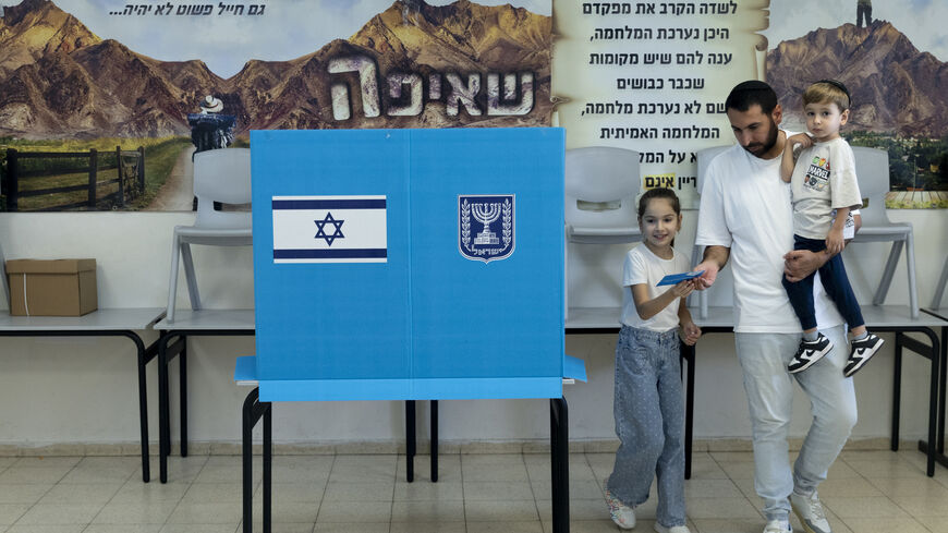 Sahar Mahluf, accompanied by his children Adir and Noya, casts his vote during Israel's general elections on October 27, 2026 in Hadera, Israel.