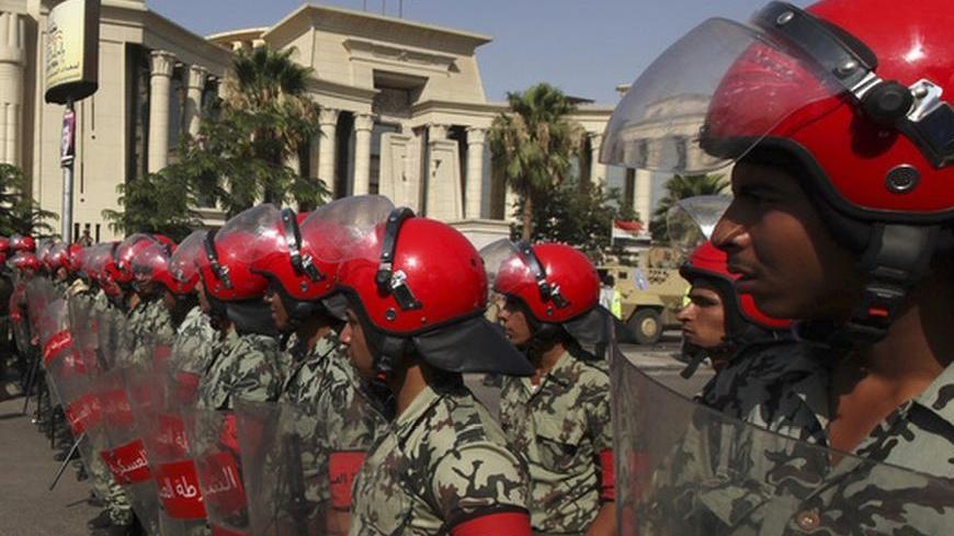 Egyptian military police stand guard outside the Supreme Constitutional Court, where a decision is expected on the validity of the law passed by the Islamist-led parliament that sought to bar Ahmed Shafik, Hosni Mubarak's last prime minister, from the vote pitting him against the Muslim Brotherhood's Mohamed Morsy, in Cairo June 14, 2012. Shafik got the green light to continue his bid for Egypt's presidency on Thursday when a constitutional court ruled against a law that would have thrown him out of the rac