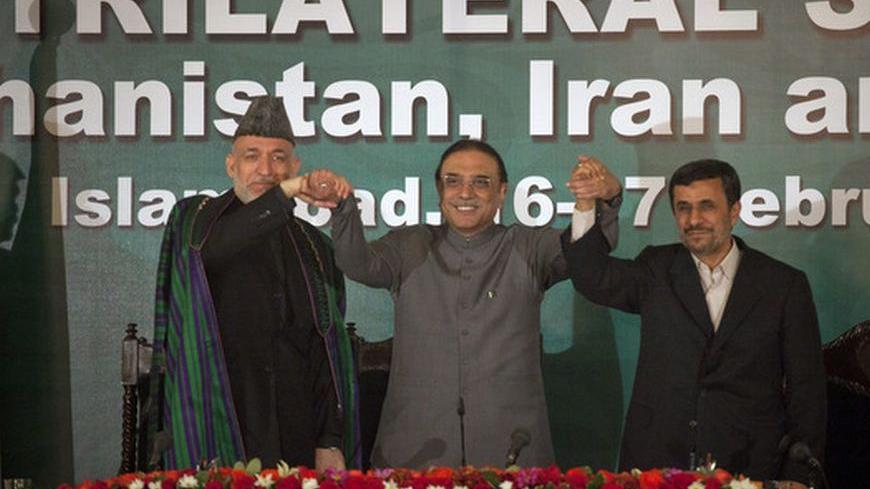 Afghanistan's President Hamid Karzai (L), Pakistan's President Asif Ali Zardari (C) and Iran's President Mahmoud Ahmadinejad join hands after a news conference in Islamabad February 17, 2012. Ahmadinejad, accused by the West of pursuing a nuclear weapons programme, said in Pakistan on Friday foreign nations were determined to dominate the region and this should not be allowed.   REUTERS/Mian Khursheed  (PAKISTAN - Tags: POLITICS)