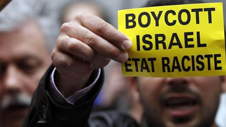 A demonstrator displays a sign reading "Boycott Israel, racist state" outside the Belgian foreign affairs building during a protest in Brussels May 31, 2010. Israel's storming of a Gaza-bound aid flotilla set off a diplomatic furore, drawing criticism from friends and foes alike and straining ties with regional ally Turkey, which called off planned joint military exercises. REUTERS/Francois Lenoir  (BELGIUM - Tags: CIVIL UNREST POLITICS IMAGES OF THE DAY)