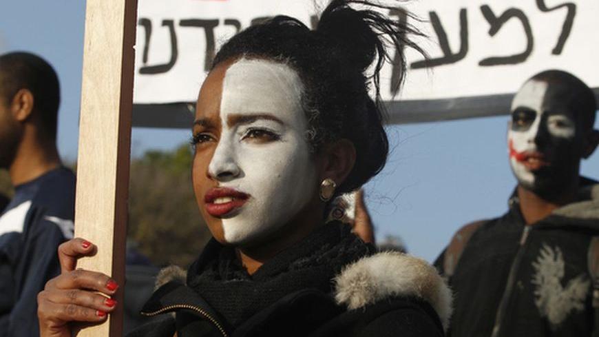 Israeli youths with their faces painted hold signs during a demonstration in protest of the discrimination against Israelis of Ethiopian descent, in Jerusalem January 18, 2012. REUTERS/Baz Ratner (JERUSALEM - Tags: POLITICS CIVIL UNREST)