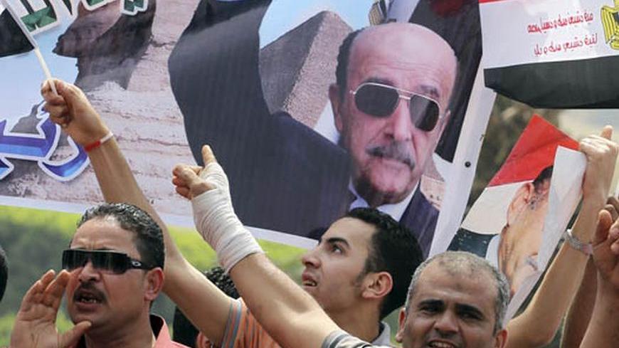 Supporters of presidential candidate and Egypt's former vice president Omar Suleiman, cheer while carrying banners bearing images of him, as Suleiman presented recommendation documents to the Higher Presidential Elections Commission (HPEC) headquarters in Cairo April 8, 2012.The intelligence chief of Egypt's deposed leader Hosni Mubarak formally joined the race for the presidency on Sunday, a last-minute entrance that raises the heat in a contest pitting former regime figures against newly-assertive Islamis