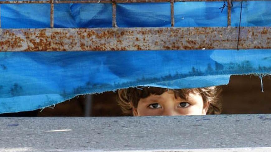 A Syrian refugee girl looks out from behind the fence at Yayladagi refugee camp in Hatay province near the Turkish-Syrian border April 10, 2012. International envoy Kofi Annan said there should be no preconditions to halting violence in Syria and that a U.N.-sponsored peace plan designed to stem 13-months of conflict was still on the table. "On the question of whether the plan is succeeding or failing, I believe it is a bit too early to say that the plan has failed. The plan is still on the table," he told 
