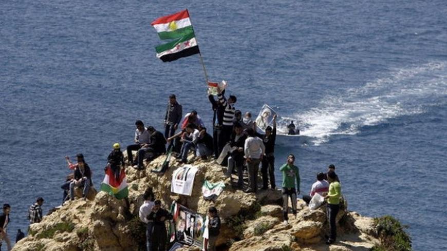Kurds hold up Syria's pre-Baath and Kurdish flags, chanting slogans against the Syrian regime as they celebrate Noruz spring festival in the lebanese capital Beirut on March 21, 2012. Noruz festival marks the Persian New Year which is an ancient Zoroastrian tradition celebrated by Iranians and Kurds coinciding with the vernal (spring) equinox and is calculated by the solar calender. AFP PHOTO/JOSEPH EID (Photo credit should read JOSEPH EID/AFP/Getty Images)