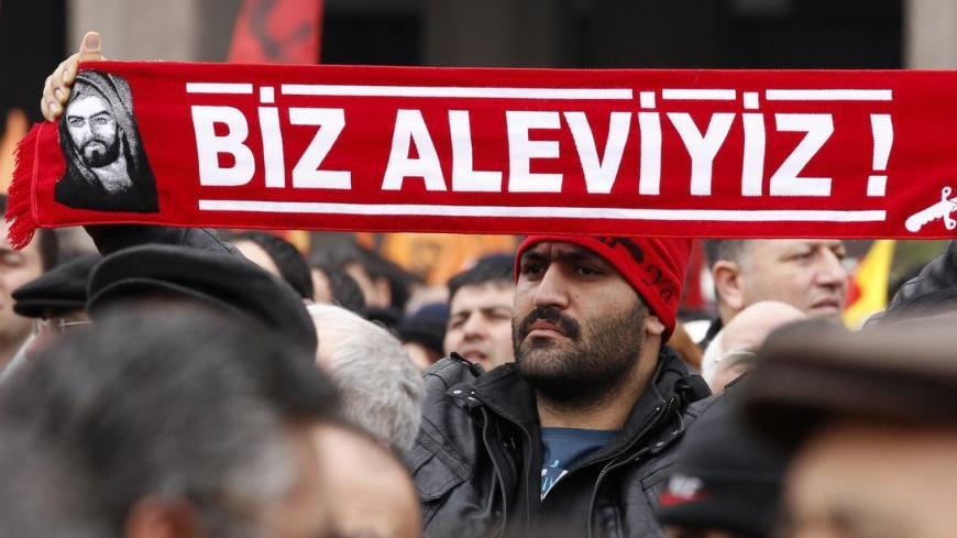 A protester holds a banner reading "we are alevi" as he and many others wait to hear the decision of the court in front of a courthouse in Ankara March 13, 2012. Turkish police fired tear-gas and water cannon to disperse hundreds protesting on Tuesday against the dropping of a case against five people charged with killing 37 writers and liberals in a 1993 hotel fire set off by Islamist rioters.The opposition accused Prime Minister Tayyip Erdogan and his AK Party, which emerged from a series of banned Islami