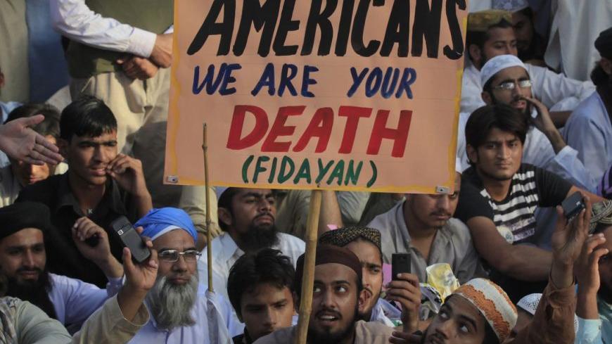 A supporter of the religious party Idara Sirat-e-Mustaqeem holds a placard during a rally with some 600 other protesters against an anti-Islam film made in the U.S. mocking Prophet Mohammad, in Lahore September 23, 2012. A Pakistani minister offered $100,000 on Saturday to anyone who kills the maker of an online video which insults Islam, as sporadic protests rumbled on across parts of the Muslim world.     REUTERS/Mohsin Raza   (PAKISTAN - Tags: POLITICS CIVIL UNREST RELIGION)