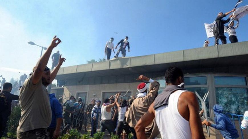 Tunisian protesters break into the US embassy in Tunis during a protest against a film mocking Islam on September 14, 2012. The demonstrators, acting aggressively, managed to clamber over one of the walls round the mission, near the car park where several vehicles had been set ablaze, the photographer said. AFP PHOTO/FETHI BELAID        (Photo credit should read FETHI BELAID/AFP/GettyImages)