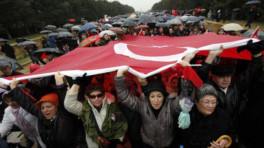 Wives of retired and active military officers charged in the so-called Sledgehammer trial march under a huge Turkish flag during a protest at Anitkabir, the mausoleum of Mustafa Kemal Ataturk, founder of secular Turkey, in Ankara February 19, 2011. Turkish police arrested nearly 200 retired and serving military officers, including former top commanders, who are accused of plotting a coup in 2003 to topple Prime Minister Tayyip Erdogan's government. The trial of alleged plotters of "Sledgehammer" reflects a 