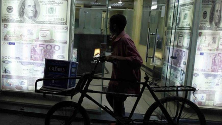 A boy pushes a bicycle as he walks past a currency exchange office in Cairo September 18, 2011. Seven months after president Hosni Mubarak was ousted, Egypt's business community is becoming more vocal in its pleas for the interim government to spell out how it plans to revive confidence in the economy, which has been badly hit by an exodus of tourists and investors. Picture taken September 18, 2011. To match feature  EGYPT-BUSINESS/ REUTERS/Mohamed Abd El-Ghany  (EGYPT - Tags: BUSINESS)