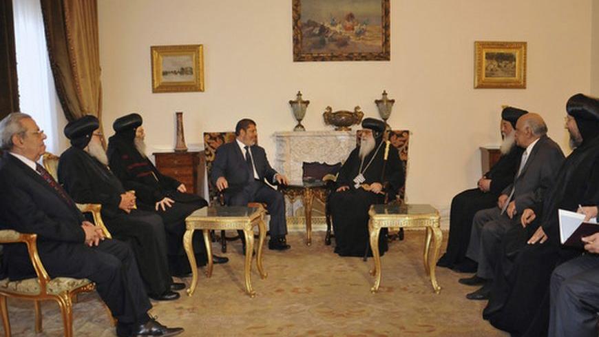 The Muslim Brotherhood's President-elect Mohamed Mursi meets with a Christian delegation headed by the caretaker pope of the country's Coptic Church, Bishop Bakhomious (C), at the presidential palace in Cairo June 26, 2012. REUTERS/Middle East News Agency (MENA)/Handout (EGYPT - Tags: POLITICS ELECTIONS RELIGION) FOR EDITORIAL USE ONLY. NOT FOR SALE FOR MARKETING OR ADVERTISING CAMPAIGNS. THIS IMAGE HAS BEEN SUPPLIED BY A THIRD PARTY. IT IS DISTRIBUTED, EXACTLY AS RECEIVED BY REUTERS, AS A SERVICE TO CLIENT