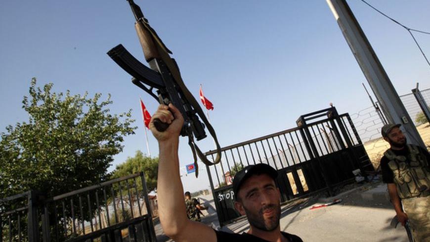 A Free Syrian Army soldier raises his rifle at the Bab Al-Salam border crossing to Turkey July 22, 2012. Syrian forces regained control of one of two border crossings seized by rebels on the frontier with Iraq, Iraqi officials said, but rebels said they had captured a third border crossing with Turkey, Bab al-Salam north of Aleppo. "Seizing the border crossings does not have strategic importance but it has a psychological impact because it demoralises Assad's force," a senior Syrian army defector in Turkey,