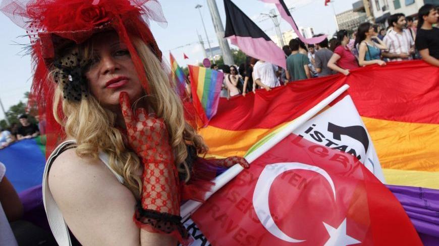 A participant holding a Turkish flag reacts to the camera during the second Trans Pride Parade in Istanbul June 19, 2011. Hundreds of trangenders and their supporters marched in central Istanbul as part of Trans Pride Week 2011, which is organized by Istanbul's "Lesbians, Gays, Bisexuals, Transvestites and Transsexuals"  (LGBTT) solidarity organization. REUTERS/Murad Sezer (TURKEY - Tags: SOCIETY)