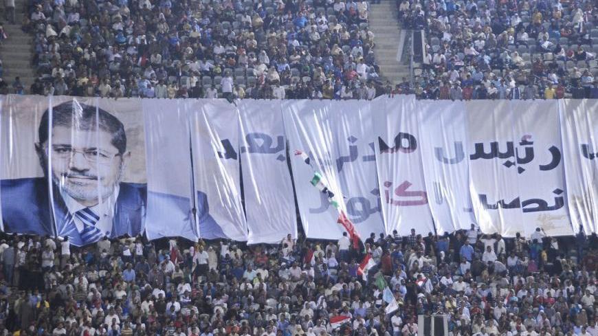 A giant banner of Egypt's President Mohamed Mursi, which reads: "Mursi is the first civilian president", is pictured as Mursi addresses the nation at Cairo stadium October 6, 2012, to mark the anniversary of Egypt's successful crossing of the Suez Canal in its October 1973 war against Israel. Mursi said on Saturday he had fallen short of goals he promised to fulfil in his first 100 days in office, but aimed to assuage critics by highlighting his most prominent achievements. REUTERS/Egyptian Presidency/Hando