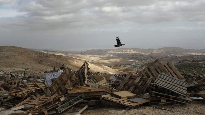 A bird flies over pieces of wood in an area near Jerusalem known as E1, where there are plans for construction of some 3,000 settler homes December 6, 2012. Germany's Angela Merkel and Israel's Benjamin Netanyahu agreed to disagree on the question of Israeli plans to build more Jewish settlements, the chancellor said on Thursday.  REUTERS/Baz Ratner (WEST BANK - Tags: POLITICS ANIMALS)