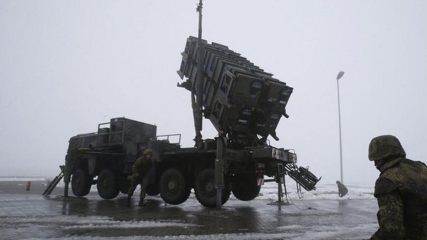 Soldiers of the German armed forces Bundeswehr stand next to a PAC-2 launcher of a "Patriot" missile battery during a media rehearsal in the north German village of Warbelow December 18, 2012. Germany's lower house of parliament, the Bundestag, last week approved the sending of two Patriot batteries and 400 soldiers to Turkey as part of a NATO plan to protect the country from any spread of the Syrian conflict. REUTERS/Tobias Schwarz (GERMANY - Tags: POLITICS MILITARY CIVIL UNREST)