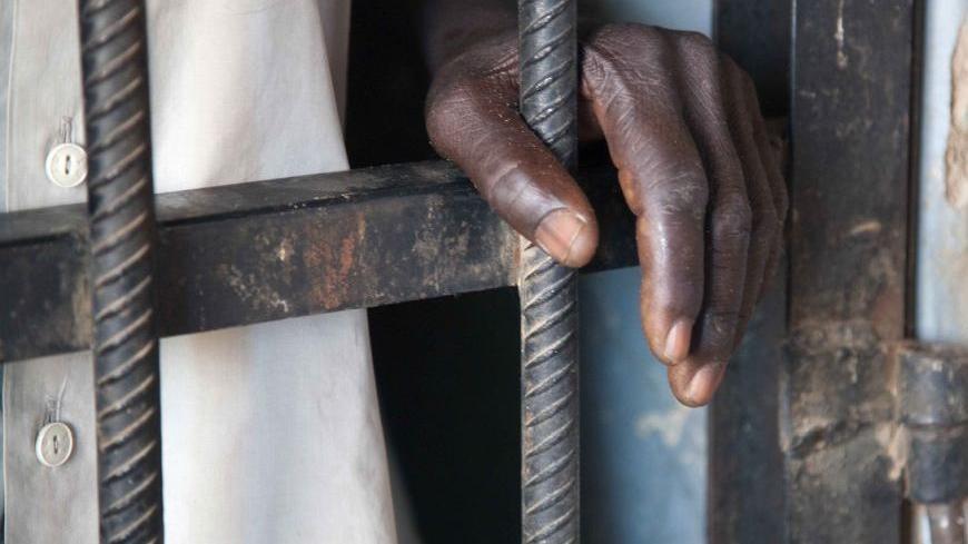 An inmate rests his hand on the bars of a prison controlled by the SLA/Mini Minawi in Shangle Tubaya village in north Darfur October 18, 2010. According to the U.N, the prison currently houses four inmates, who share a cell and are given food twice daily. Of the four, some have been jailed for several weeks without having a trial or legal representatives. Picture taken October 18, 2010. REUTERS/UNAMID/Albert Gonzalez Farran/Handout  (SUDAN - Tags: POLITICS CRIME LAW IMAGES OF THE DAY) FOR EDITORIAL USE ONLY