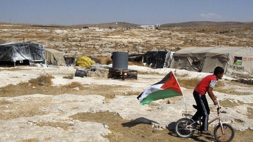A Palestinian boy rides a bicycle past tents in the West Bank village of Susiya June 24, 2012. Susiya the Israeli settlement enjoys well-watered lawns, humming electricity, and the protection of a mighty state. One rocky hill away, Susiya the Palestinian village is parched and doomed. Picture taken June 24, 2012. To match Feature ISRAEL-PALESTINIANS/DEMOLITION   REUTERS/Baz Ratner (WEST BANK - Tags: POLITICS)