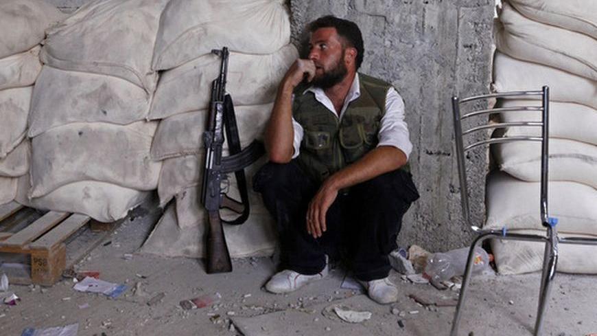 A member of the Free Syrian Army rests at a front line in the Hanano area of Aleppo city in northern Syria October 10, 2012. REUTERS/Zain Karam (SYRIA - Tags: CIVIL UNREST POLITICS)
