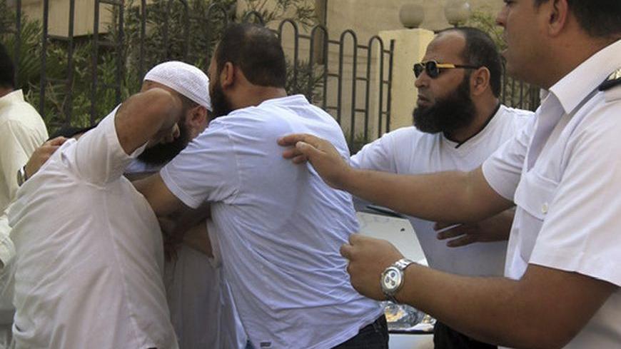 A police officer (R) tries to break up a scuffle between two Egyptian hardline Salafists and a Coptic Christian man (L) outside the courthouse in Cairo October 14, 2012, after the trial of Ahmed Mohamed Abdullah, known as Abu Islam. Abu Islam has been charged with burning the Bible in front of the U.S. Embassy in Cairo during a mass protest against a film insulting Islam's Prophet Mohamed. REUTERS Mohamed Abd El Ghany  (EGYPT - Tags: CIVIL UNREST POLITICS RELIGION)