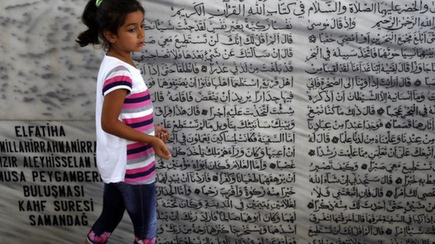 A girl stands in a tomb, a holy site for the Alawite community, in the Samandag district of Hatay province, close to the border with Syria, July 27, 2012. An influx of Syrians fleeing President Bashar al-Assad's military onslaught is stoking tension in an area of Turkey known for religious tolerance and setting Turks who share the Syrian leader's creed against their own government. In the Turkish frontier province of Hatay, home to the Antioch of the Bible and a mix of confessional groups rare in an overwhe