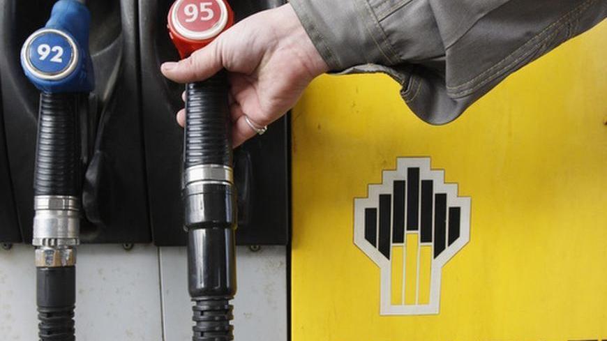 An attendant holds a gas pump at a Rosneft petrol station in St.Petersburg October 23, 2012. Russian oil company Rosneft tightened its grip on Russia's oil industry on Monday with a $55 billion deal to buy TNK-BP that also makes Britain's BP a one-fifth shareholder in the state-controlled company.  REUTERS/Alexander Demianchuk (RUSSIA - Tags: BUSINESS ENERGY)
