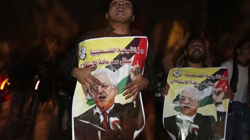 Palestinians hold posters depicting President Mahmoud Abbas as they celebrate on a street in Gaza City November 30, 2012. The 193-nation U.N. General Assembly overwhelmingly approved a resolution on Thursday to upgrade the Palestinian Authority's observer status at the United Nations from "entity" to "non-member state," implicitly recognizing a Palestinian state.  REUTERS/Mohammed Salem (GAZA - Tags: POLITICS)