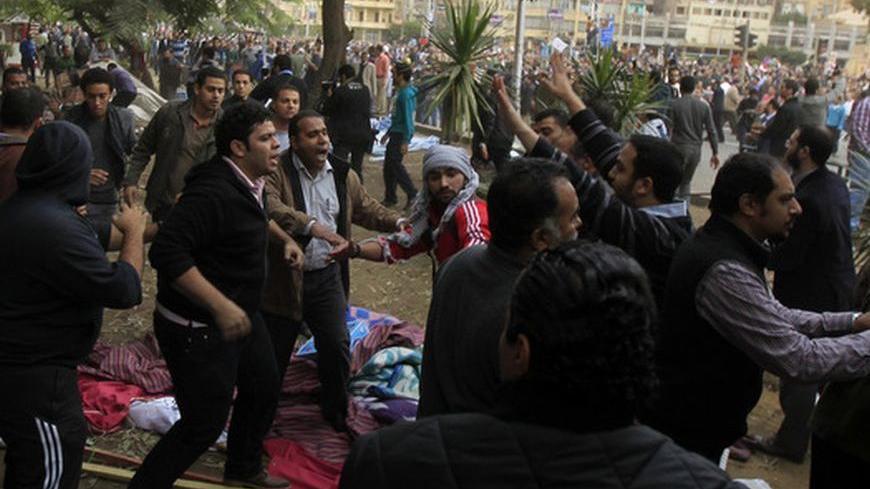 Muslim Brotherhood supporters of Egypt's President Mohammed Mursi fight with an anti-Morsi protester during clashes outside the presidential palace in Cairo December 5, 2012. Islamists fought protesters outside the Egyptian president's palace on Wednesday, while inside the building his deputy proposed a way to end a crisis over a draft constitution that has split the most populous Arab nation. REUTERS/Mohamed Abd El Ghany (EGYPT - Tags: POLITICS CIVIL UNREST)