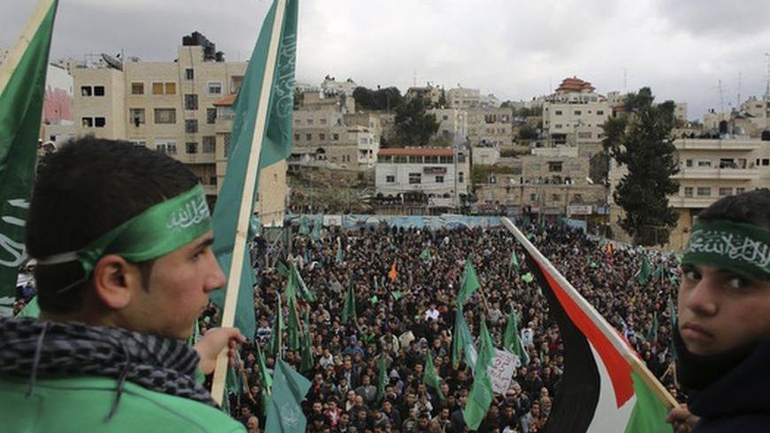 Hamas supporters wave flags during a rally in the West Bank city of Hebron, marking the 25th anniversary of the founding of the Islamist militant group, December 14, 2012. It was one of the first rallies Western-backed Palestinian President Mahmoud Abbas allowed to take place in the West Bank since 2007, when his Islamist rivals Hamas seized control of the Gaza Strip. REUTERS/Ammar Awad (WEST BANK - Tags: POLITICS ANNIVERSARY)