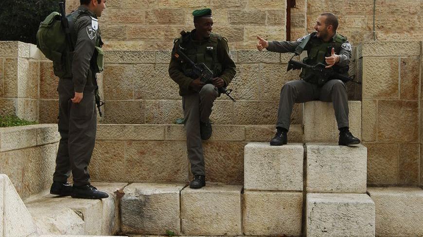 Israeli border policemen chat behind a police barrier during Friday prayers in Jerusalem's Old City December 14, 2012. REUTERS/Amir Cohen (JERUSALEM - Tags: RELIGION MILITARY)