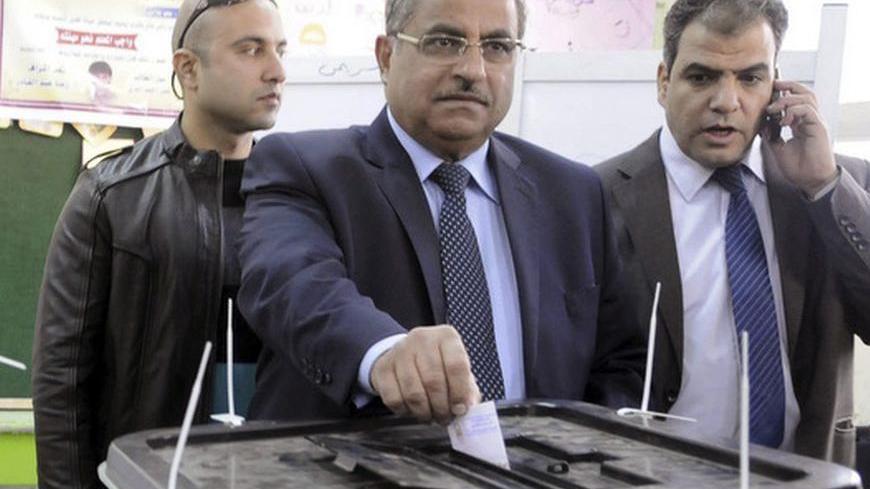 Shura Council Chairman Ahmed Fahmy (C) casts his vote in a referendum on Egypt's new constitution, at a polling station in Zagazig, Sharqiya Governorate, about 62.5 km (38.8 miles) northeast of Cairo December 15, 2012. Egyptians queued in long lines on Saturday to vote on a constitution promoted by its Islamist backers as the way out of a political crisis and rejected by opponents as a recipe for further divisions in the Arab world's biggest nation. REUTERS/Stringer  (EGYPT - Tags: POLITICS ELECTIONS)