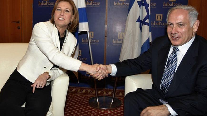 Israel's Likud party leader Benjamin Netanyahu (R) shakes hands with Foreign Minister and Kadima party leader Tzipi Livni in Jerusalem February 22, 2009. Right-wing leader Netanyahu on Friday accepted a mandate to form Israel's next government and immediately called for a broad, national unity coalition with centrist and left-wing partners.   REUTERS/Ammar Awad (JERUSALEM)