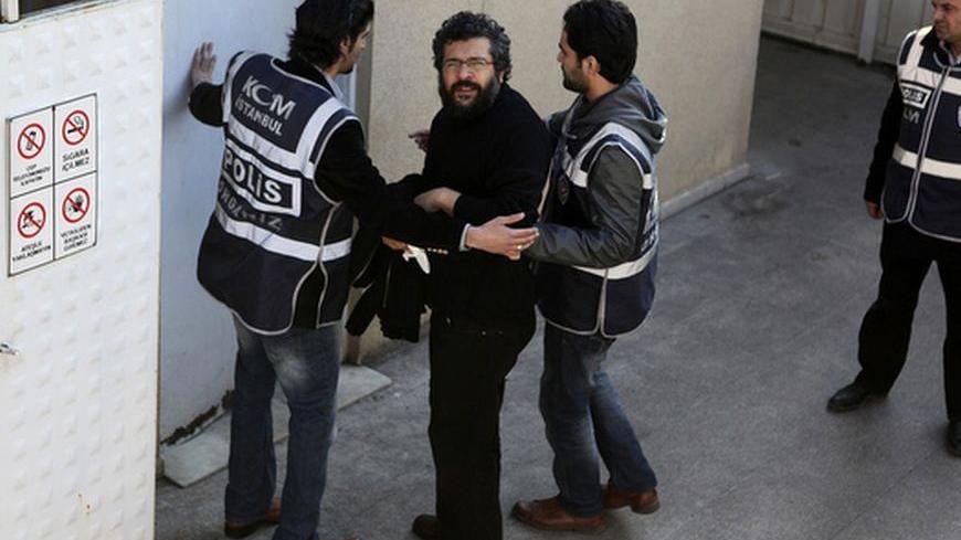 Journalist Soner Yalcin (2nd L) is escorted by plainclothes policemen upon his arrival at a courthouse in Istanbul February 17, 2011. The prominent Turkish journalist was charged on Friday with links to a shadowy, ultra-nationalist group accused of seeking to overthrow the government, joining two of his colleagues in jail pending trial. Soner Yalcin, who runs a news website fiercely critical of the government, was detained earlier this week in a case which triggered a diplomatic spat between Turkish officia