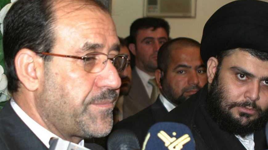 Iraq's Prime Minister Nuri al-Maliki (L) stands next to Shi'ite cleric Moqtada al-Sadr during a news conference in Najaf, 160 km (100 miles) south of Baghdad October 18, 2006. Maliki travelled to the holy city of Najaf on Wednesday and met Sadr and Grand Ayatollah Ali al-Sistani, the leading Shi'ite cleric in Iraq.   REUTERS/AliAbu Shish  (IRAQ)