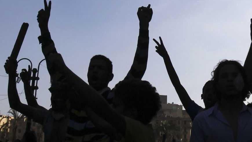 Protesters are silhouetted as they shout slogans and flash victory signs during clashes with riot police along a road which leads to the U.S. embassy, near Tahrir Square in Cairo September 13, 2012. Egypt's President Mohamed Mursi said on Thursday he supported peaceful protest but not attacks on embassies, after Egyptians angry at a film deemed insulting to the Prophet Mohammad climbed into the U.S. embassy in Cairo and tore down the U.S. flag. He pledged to protect foreigners in Egypt. REUTERS/Amr Abdallah