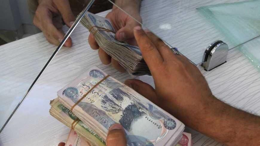 A customer changes U.S. dollars to Iraqi dinars at a money changer in Baghdad October 1, 2012. Many Iraqis have lost faith in their dinar currency but to some foreign speculators, it promises big profits. The contrast underlines the uncertainties of investing in Iraq as the country recovers from years of war and economic sanctions. Picture taken October 1, 2012. To match IRAQ-ECONOMY/DINAR REUTERS/Saad Shalash (IRAQ - Tags: BUSINESS POLITICS)