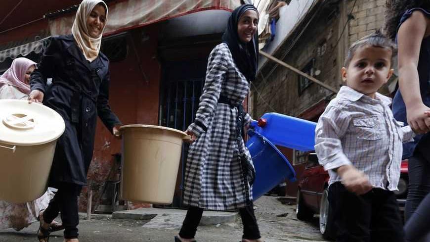 Syrian refugees carry tools donated by humanitarian activists on the first day of Eid al-Adha in Beirut October 26, 2012. Muslims around the world celebrate Eid al-Adha, marking the end of the haj, by slaughtering sheep, goats, cows and camels to commemorate Prophet Abraham's willingness to sacrifice his son Ismail on God's command. REUTERS/Jamal Saidi    (LEBANON - Tags: RELIGION SOCIETY)