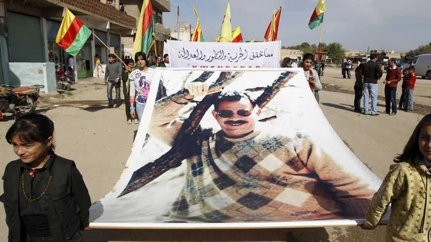 Syrian Kurds demonstrators hold a giant portrait of jailed Kurdistan Workers Party (PKK) leader Abdullah Ocalan during a protest in Derik, Hasakah November 1, 2012. Around 1,000 Syrian Kurds protested in the north-eastern Syrian town of Derik on Thursday, demanding the re-opening of Kurdish-language schools they said were closed by President's Bashar al-Assad's regime.  REUTERS/Thaier al-Sudani (SYRIA - Tags: POLITICS CIVIL UNREST CONFLICT EDUCATION)