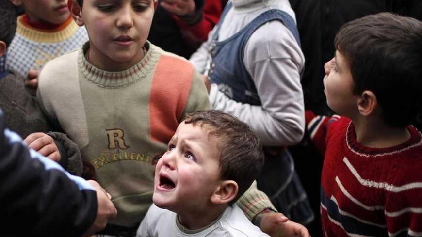A Syrian child refugee cries as he stands at a queue waiting to receive aid from Turkish humanitarian agencies at Bab al-Salam refugee camp in Syria near the Turkish border December 22, 2012. International envoy Lakhdar Brahimi will visit Syria in the next few days and is expected to meet President Bashar al-Assad, government officials and some opposition factions, a source in the Arab League said. REUTERS/Ahmed Jadallah (SYRIA - Tags: CIVIL UNREST POLITICS)