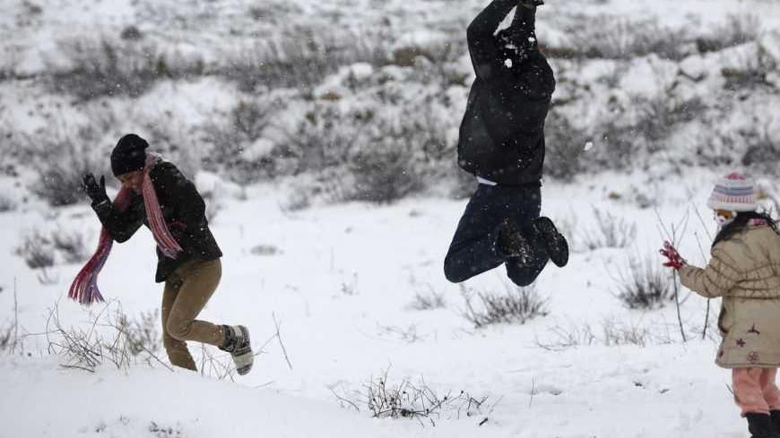 Palestinians play in the snow in the West Bank city of Ramallah January 10, 2013. At least 17 people have died due to a storm in Lebanon, Jordan, Turkey, Israel and the Palestinian territories. Meteorological agencies in Israel and Lebanon both called it the worst storm in 20 years. REUTERS/Mohamad Torokman (WEST BANK - Tags: ENVIRONMENT)