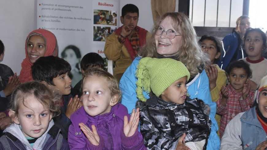 U.S. actress Mia Farrow (C), a UNICEF goodwill ambassador, sits with children of Syrian refugees at an UNICEF office in Wadi Khaled, north Lebanon, January 14, 2013. Farrow is on a two day visit to Lebanon, meeting Syrian refugees. REUTERS/Roula Naeimeh (LEBANON - Tags: SOCIETY POLITICS ENTERTAINMENT)