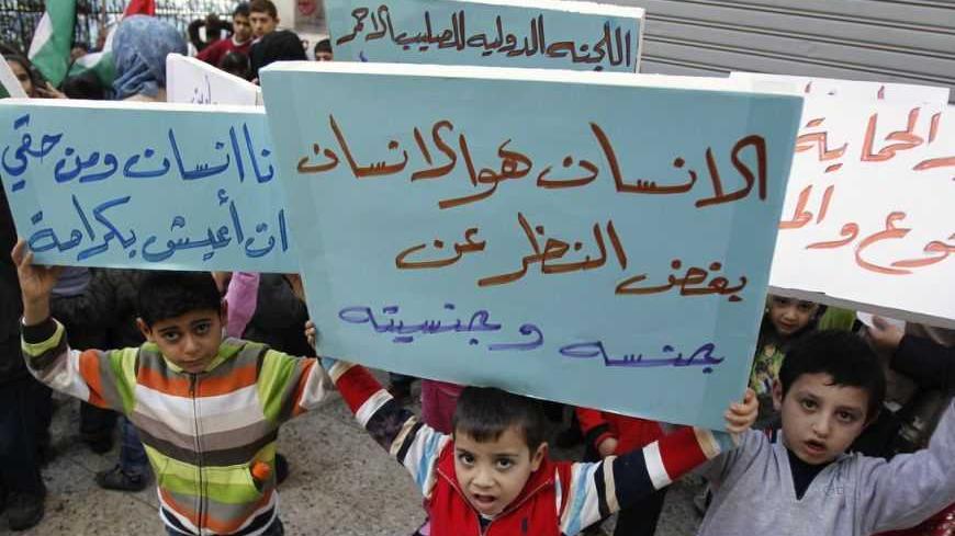 Palestinian children who were living in Yarmouk Palestinian refugee camp before fleeing Syria, hold banners during a protest in front of the International Committee of the Red Cross (ICRC) in Beirut  January 17, 2013. Banners read, "Man is man, regardless of gender and nationality" (C), "I am a human and I have the right to live with dignity" (L) and "We want protection from hunger and diseases".   REUTERS/Sharif Karim (LEBANON - Tags: SOCIETY IMMIGRATION POLITICS CONFLICT)