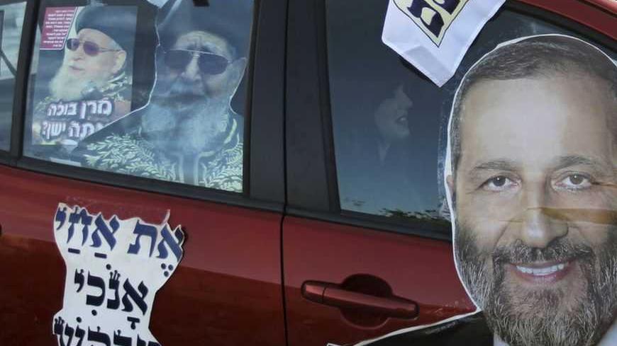 Ultra-Orthodox Shas party campaign stickers depicting party leader Aryeh Deri (R) and spiritual leader, Rabbi Ovadia Yosef (L), are seen on a car in Jerusalem January 17, 2013. A fixture in successive governments, Shas, the ultra-Orthodox party draws its support from the fast-growing community of religious Jews of Middle Eastern origin whose spiritual leader is the 92-year-old, Iraqi-born rabbi Ovadia Yosef. According to opinion polls, it will maintain its 11 seats in parliament. REUTERS/Ammar Awad (JERUSAL