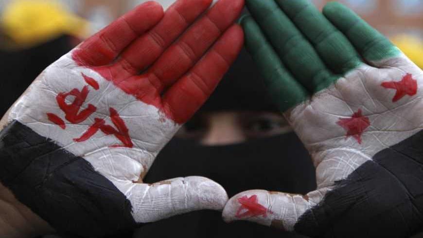 A pro-democracy protester displays her palms that are painted with the national colours of Syria during a demonstration in Sanaa January 17, 2013. The demonstrators were calling for Yemen's President Abd-Rabbu Mansour Hadi to make more decisions to complete the preparations for national dialogue and to demand that Yemen's former president Ali Abdullah Saleh be put on trial, according to organisers. REUTERS/Mohamed al-Sayaghi (YEMEN - Tags: CIVIL UNREST POLITICS)