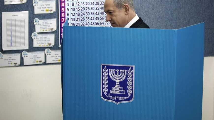 Israel's Prime Minister Benjamin Netanyahu stands behind a booth as he casts his ballot for the parliamentary election at a polling station in Jerusalem January 22, 2013. Israelis voted on Tuesday in an election that is expected to see Netanyahu win a third term in office, pushing the Jewish state further to the right, away from peace with the Palestinians and towards a showdown with Iran. REUTERS/Uriel Sinai/Pool (JERUSALEM - Tags: POLITICS ELECTIONS)