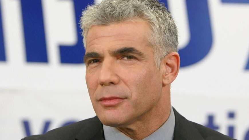 Yair Lapid, leader of the Yesh Atid (There's a Future) party, pauses while addressing supporters at his party's headquarters in Tel Aviv January 23, 2013. Lapid, a former television news anchor whose new centrist party stormed to second place in Israel's election, may well be the kingmaker holding the keys to the next coalition government. REUTERS/Ammar Awad (ISRAEL - Tags: POLITICS ELECTIONS PROFILE HEADSHOT)