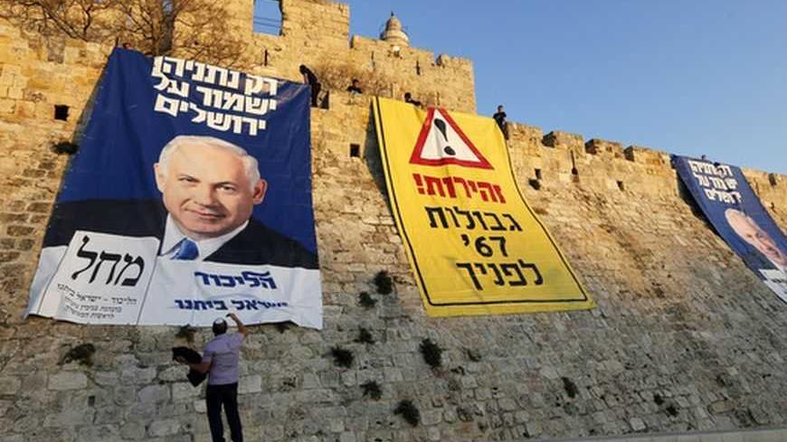A man stands next to campaign banners depicting Israel's Prime Minister Benjamin Netanyahu after Likud-Yisrael Beitenu activists draped them on walls surrounding Jerusalem's Old City January 20, 2013. Netanyahu said on Saturday a country with as many enemies as Israel cannot afford a weak ruling party, after polls ahead of Tuesday's parliamentary election showed a slide in his support. The banners read (L and C) "Only Netanyahu will protect Jerusalem" and "Warning! '67 borders ahead". REUTERS/Ronen Zvulun (