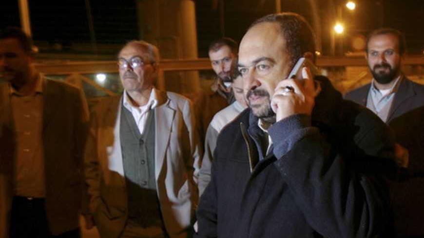 Palestinian Public Works and Housing Minister Abdel-Rahman Zidan (R) of Hamas speaks on his cell phone at a checkpoint on the outskirts of the West Bank city of Jenin November 29, 2006. Israeli authorities on Wednesday released one of the Hamas government ministers it detained after gunmen from the Gaza Strip abducted an Israeli soldier in June, witnesses said. REUTERS/Mohamad Torokman  (WEST BANK)
